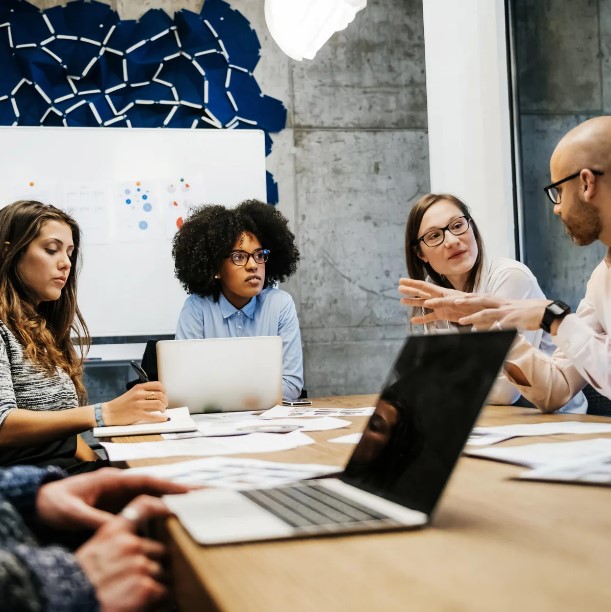 Group of people sitting at a table in a work meeting.